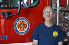 Craig Brooks stands next to one of the Carancahua Volunteer Fire Dept. trucks.