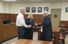 Pam Guenther shakes the hand of Judge Bobby Bell as he swears her in as Jackson County's new D.A. 