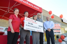 Sue Sims, her husband Eddie Sims, and Brookshire Brothers emplyees hold her $100,000 check.